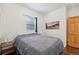 Bedroom with wood floors and a queen bed, features a window and mountain scene wall art at 2203 S Lincoln St, Denver, CO 80210