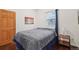 Bedroom featuring a queen bed, window with blinds, and a sunset scene wall art at 2203 S Lincoln St, Denver, CO 80210