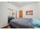 Bedroom with wood floors features a queen bed, sliding closet doors, and a sunset scene wall art at 2203 S Lincoln St, Denver, CO 80210