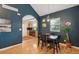 Dining room with an open layout, wood floors, and inviting arched entryway to a modern kitchen at 2203 S Lincoln St, Denver, CO 80210