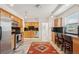Bright kitchen featuring wooden cabinets, stainless steel appliances, bar seating and a decorative rug at 2203 S Lincoln St, Denver, CO 80210