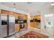 Well-lit kitchen featuring stainless steel appliances, wooden cabinets, and a decorative rug on tile flooring at 2203 S Lincoln St, Denver, CO 80210