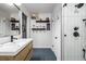 Stylish bathroom features unique blue tile flooring, floating shelves and a tiled walk-in shower at 2845 Hudson St, Denver, CO 80207