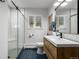Bright bathroom features a modern vanity, unique blue tile flooring, and a glass-enclosed shower at 2845 Hudson St, Denver, CO 80207