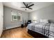 Cozy bedroom with hardwood floors, ceiling fan, and a large window providing natural light at 2845 Hudson St, Denver, CO 80207