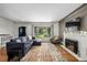 Bright living room with a fireplace, hardwood floors, and a large window at 2845 Hudson St, Denver, CO 80207