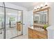 Bathroom showcases a wood vanity, mirrors, tile floors, and an open view into bedroom at 6083 S Glencoe Way, Centennial, CO 80121