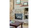 Detailed view of a stone fireplace in living room, complete with wooden shelves and firewood storage at 6083 S Glencoe Way, Centennial, CO 80121