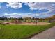 Daytime shot of neighborhood playground with swings and slides on a well-maintained green lawn at 6083 S Glencoe Way, Centennial, CO 80121
