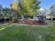 Green backyard featuring a two-story home with a small second story balcony and shade trees at 7163 S Xanthia St, Centennial, CO 80112