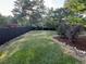 Well-maintained backyard featuring lush green grass, manicured landscaping, and a dark wood privacy fence at 7163 S Xanthia St, Centennial, CO 80112