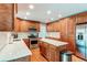 Well-lit kitchen features stainless steel appliances, a kitchen island, white countertops, and light wood cabinetry at 7163 S Xanthia St, Centennial, CO 80112