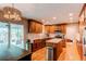 Kitchen featuring custom cabinets, an island, stainless steel appliances, and hardwood floors at 7163 S Xanthia St, Centennial, CO 80112