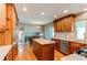 Well-lit kitchen featuring custom cabinets, an island, stainless steel appliances, and hardwood floors at 7163 S Xanthia St, Centennial, CO 80112