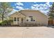 Tan home with a ramp leading to the front door and large concrete driveway at 8843 W Phillips Dr, Littleton, CO 80128