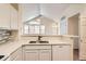 Kitchen with white cabinets and a view of the vaulted ceiling and living room at 8843 W Phillips Dr, Littleton, CO 80128