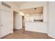 Bright living room and kitchen feature an open layout, white cabinets, and wood-look floors at 8843 W Phillips Dr, Littleton, CO 80128