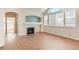 Spacious living room featuring a fireplace, large windows, and wood-look floors at 8843 W Phillips Dr, Littleton, CO 80128
