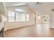 Living room featuring a vaulted ceiling, large windows, and wood-look floors at 8843 W Phillips Dr, Littleton, CO 80128