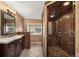 Elegant bathroom featuring a double vanity, tiled walls, decorative lighting, and a luxurious walk-in shower at 1415 S Jasmine Way, Denver, CO 80224