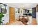 Bright dining area with a glass-top table, wooden chairs, hardwood floors, and views of the modern kitchen at 1415 S Jasmine Way, Denver, CO 80224