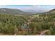 Aerial view of a log home nestled in a forest with mountain views at 6241 Kilimanjaro Dr, Evergreen, CO 80439