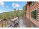 Exterior of wooden deck with seating, a mountain view and a beautiful log home at 6241 Kilimanjaro Dr, Evergreen, CO 80439