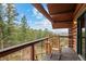 Relaxing wooden balcony offers stunning mountain and forest views from this log home at 6241 Kilimanjaro Dr, Evergreen, CO 80439