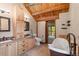 Log home bathroom featuring a soaking tub, double sinks, and wood accents at 6241 Kilimanjaro Dr, Evergreen, CO 80439
