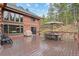 Large deck with outdoor seating area, grill, and views of the lush backyard at 6241 Kilimanjaro Dr, Evergreen, CO 80439