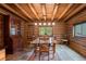 Cozy dining room featuring log walls, rustic wood table, a decorative rug, and stone floors, perfect for Gathering meals at 6241 Kilimanjaro Dr, Evergreen, CO 80439