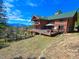 Charming log home with a green roof and a large deck offering stunning mountain views at 6241 Kilimanjaro Dr, Evergreen, CO 80439