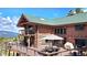 Exterior view of a log home with a large deck and mountain views in the background at 6241 Kilimanjaro Dr, Evergreen, CO 80439