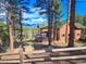 Beautiful log home with a large deck overlooking a wooded landscape at 6241 Kilimanjaro Dr, Evergreen, CO 80439