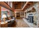 Inviting living room showcasing a stone fireplace, log beams, and cozy seating at 6241 Kilimanjaro Dr, Evergreen, CO 80439