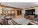 Open-concept living room with exposed beams, showcasing a large screen TV and stylish rug at 6241 Kilimanjaro Dr, Evergreen, CO 80439