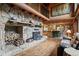 Open-concept living space with a stone fireplace, wood floors, and view to the kitchen at 6241 Kilimanjaro Dr, Evergreen, CO 80439