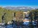 Breathtaking mountain view with snow capped peaks overlooking a lush forest and neighborhood at 6241 Kilimanjaro Dr, Evergreen, CO 80439
