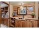 Charming powder room featuring log walls, a copper sink, granite countertop, and a rustic wood cabinet at 6241 Kilimanjaro Dr, Evergreen, CO 80439