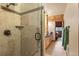 Custom shower features glass doors, stone tile, and a seamless transition to the nearby bathroom at 6241 Kilimanjaro Dr, Evergreen, CO 80439