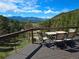 Outdoor dining table with stunning mountain and green tree views, providing a relaxing outdoor experience at 6241 Kilimanjaro Dr, Evergreen, CO 80439