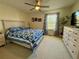 Bright bedroom features a ceiling fan, patterned quilt, and a window with patterned curtains at 1732 S Blackhawk Way # D, Aurora, CO 80012