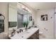 Updated bathroom with double sinks, modern fixtures, and decorative tile in the shower at 2481 Garrison St, Lakewood, CO 80215