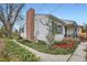 Charming home showcases well-maintained landscaping, a brick chimney, and sidewalk access at 2481 Garrison St, Lakewood, CO 80215