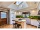 Bright, updated kitchen with skylight, green backsplash, stainless appliances, and an island with seating at 2481 Garrison St, Lakewood, CO 80215