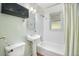Bright bathroom featuring a pedestal sink, storage cabinet, and shower-tub combo at 2595 S Irving St, Denver, CO 80219