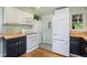 White kitchen with butcher block counters, white appliances and hardwood floors at 2595 S Irving St, Denver, CO 80219