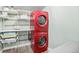 Modern laundry room featuring stacked red washer and dryer units with shelving at 2595 S Irving St, Denver, CO 80219