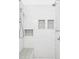 Modern bathroom features bright white tile, shower head, and built-in shelving at 2909 Glenarm Pl, Denver, CO 80205