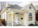Inviting yellow brick home with a cozy front porch featuring decorative white pillars and trim at 2909 Glenarm Pl, Denver, CO 80205